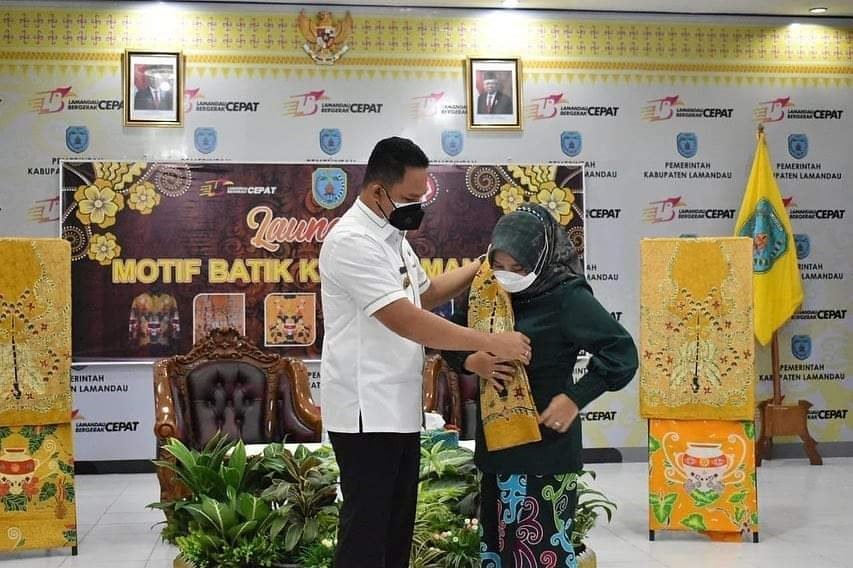 PEMKAB LAMANDAU DIRESMIKAN: Bupati Lamandau H Hendra Lesmana menyerahkan selendang batik motif Lamandau kepada Ketua Dekranasda Lamandau Hj Rusdianti Hendra Lesmana, tanda diluncurkannya sebelas motif batik Lamandau. (FOTO:HUMAS UNTUK KALTENG POS)