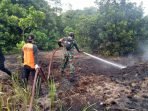 BAWAH-Panas Terik Matahari Tak Menyurutkan Semangat Petugas Gabungan Padamkan Karhutla