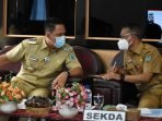 Pemkab Lamandau HADIR : Bupati Lamandau H Hendra Lesmana (kiri) berbincang dengan Sekda Lamandau Muhamad Irwansyah saat rakordal di Aula Bappeda Lamandau, belum lama ini. (FOTO: HUMAS UNTUK KALTENG POS)