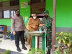 UTAMA-Cek Kesiapan Sekolah PENGECEKAN: Danramil 1015-09/Baamang Kapten Inf Wiranto ikut memantau pelaksanaan pendaftaran PPDB 2021 dan mengecek penerapan protokol kesehatan di SMPN-3 Sampit, Senin (30/8). (FOTO: PENREM 102/Pjg)