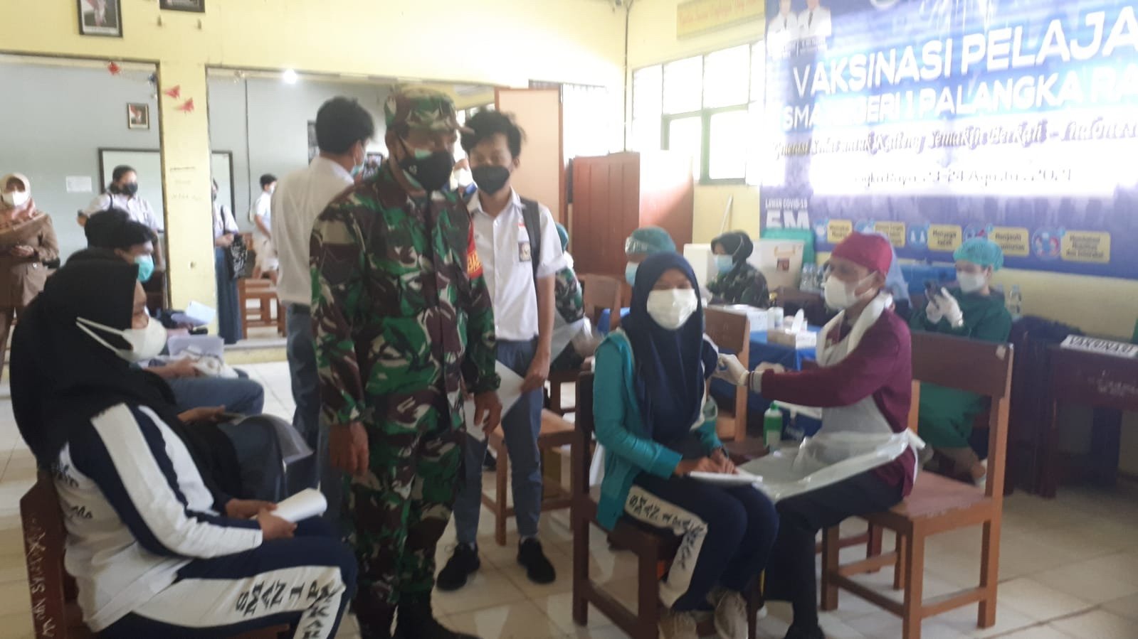 UTAMA-TNI AD Kembali Gelar Vaksinasi Untuk Pelajar di Palangka Raya VAKSINASI PELAJAR: Ratusan pelajar bergantian antre mengikuti vaksinasi Covid-19 di Aula SMAN 1 Kota Palangka Raya, Senin (23/8). (FOTO: PENREM 102/Pjg)