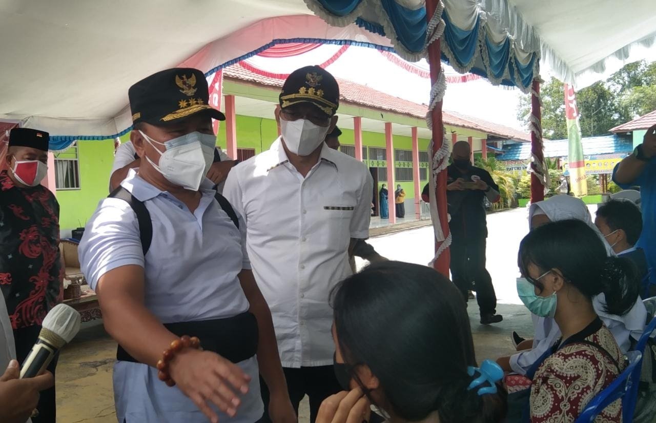 KUNJUNGAN GUBERNUR KE MURA BERI DUKUNGAN: Bupati Mura Perdie M Yoseph mendampingi Gubernur Kalteng Sugianto Sabran memantau jalannya vaksinasi massal bagi pelajar di SMAN 1 Murung, Sabtu (18/9). (FOTO: DADANG/KALTENG POS)
