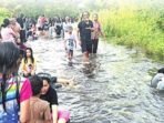 Warga bermain air di jalan Barito Raya Buntok yang terendam banjir