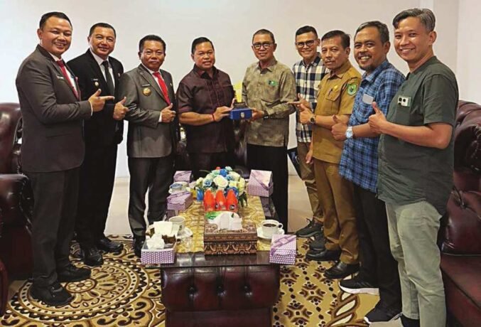 KENANG-KENANGAN: Wakil Ketua I DPRD Kapuas Yohanes menerima cendera mata dari Direktur PT Kalteng Pos Press Dr HM Wahyudie F Dirun, Senin (26/5).