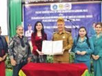 gumas MENUNJUKKAN: Bupati Gunung Mas Jaya S. Monong, mendampingi istrinya saat penandatangan di aula Bapperida setempat, Selasa (27/5).