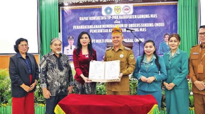 MENUNJUKKAN: Bupati Gunung Mas Jaya S. Monong, mendampingi istrinya saat penandatangan di aula Bapperida setempat, Selasa (27/5).