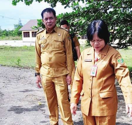 BARITO TIMUR CEK JALAN: Bupati Bartim, M Yamin (kiri) melihat kondisi jalan berlubang yang ada dihalaman Kantor Kesbangpolinmas, belum lama ini.