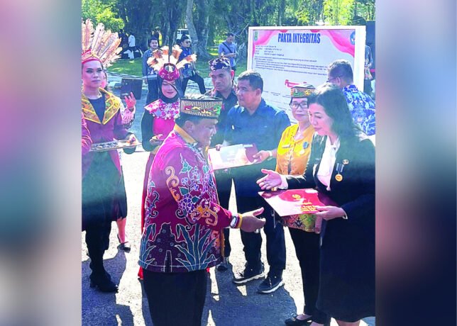 HADIR: Ketua DPRD Kapuas Ardiansah menyerahkan lencana dalam rangka peringatan Hardiknas dan Hari Otda, di halaman Kantor Bupati Kapuas, Kamis (8/5).