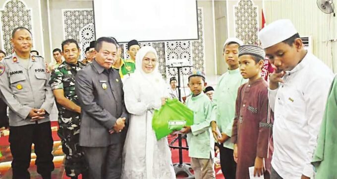 BERBAGI: KETUA TP PKK KAPUAS HJ SITI SANIAH WIYATNO BERSAMA BUPATI KAPUAS HM WIYATNO MENYERAHKAN BINGKISAN SAAT LEBARAN YATIM DAN DIFABEL, JUMAT (4/7).