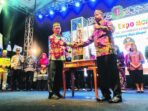 PENYERAHAN: Wakil Bupati Katingan, Firdaus menyerahkan piala kepada Camat Katingan Hilir Dony Merianto yang sukses terpilih sebagai juara Umum FBPHS 2025 di sport center Kasongan, Senin malam (21/7).