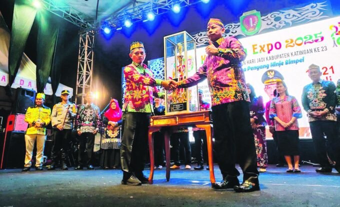 KATINGAN PENYERAHAN: Wakil Bupati Katingan, Firdaus menyerahkan piala kepada Camat Katingan Hilir Dony Merianto yang sukses terpilih sebagai juara Umum FBPHS 2025 di sport center Kasongan, Senin malam (21/7).