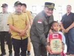 PENDIDIKAN: Ketua DPRD Kapuas Ardiansah didampingi Wakil Ketua II DPRD Kapuas Berinto menyerahkan tas kepada anak saat kunjungan kerja ke Kecamatan kapuas Tengah, Selasa (5/8).