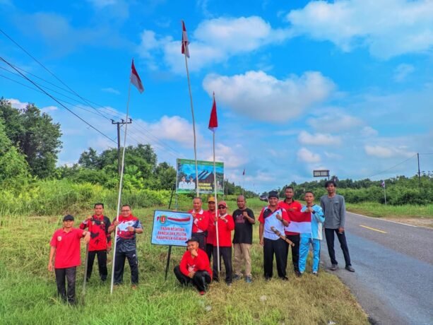 BERKIBAR - Kepala Badan Kesbang Pol Kabupaten Katingan Roby (ketiga dari kiri) dan jajarannya, ketika memasang bendera merah putih di kiri kanan badan jalan di wilayah Kabupaten Katingan, Jumat (1/8).