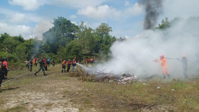 KOTIM SIMULASI: Tim gabungan saat melakukan pemadaman kebakaran lahan dalam simulasi yang dilaksanakan, Rabu (6/8).