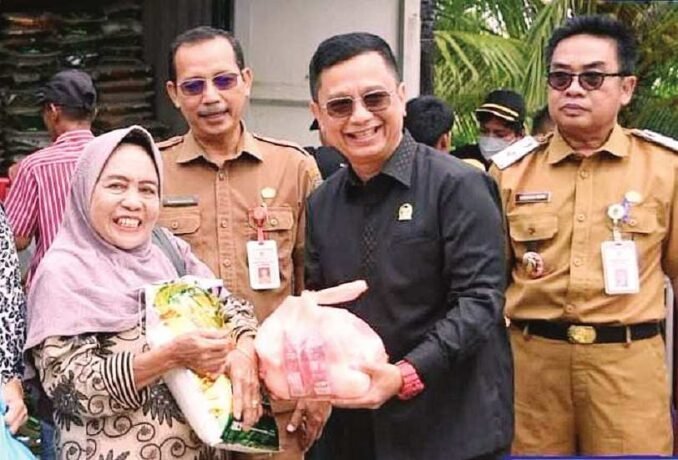 SERAHKAN SEMBAKO: Ketua Komisi II DPRD Barito Utara, H Taufik Nugraha menyerahkan sembako kepada warga saat menghadiri operasi pasar murah yang dilaksanakan di area SPBU Perusda Batara Membangun, Senin (15/9).