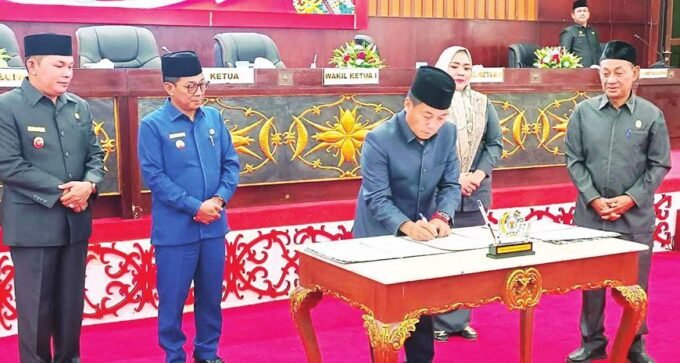 PENANDATANGANAN: Ketua DPRD Murung Raya, Rumiadi, menandatangani dokumen Raperda Perubahan APBD 2025 yang baru saja ditandatangani bersama kepada Bupati Murung Raya, Heriyus.