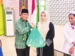 PENYERAHAN: Ketua Komisi I DPRD Mura, Rejikinoor (kiri) menyerahkan bingkisan saat Lebaran Yatim dan Difabel, Jumat (4/7).