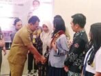 PALANGKA RAYA MENGUKUHKAN: Plt Wali Kota Palangka Raya, Achmad Zaini memasang selempang kepada pelajar Duta Trantibum, di Aula Kantor Satpol PP Kota Palangka Raya, Senin (1/9)
