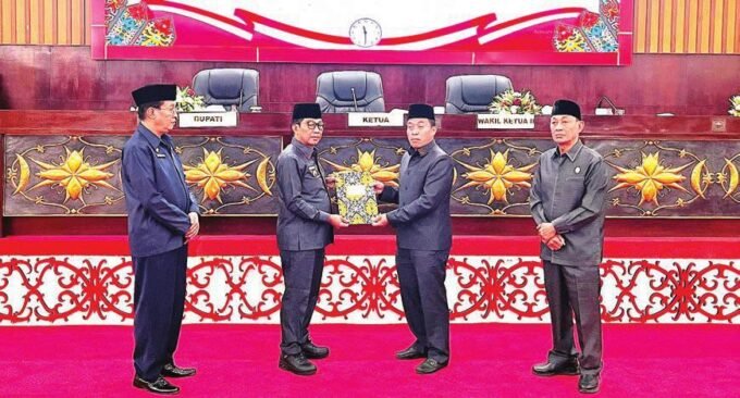 SERAH TERIMA: Bupati Murung Raya, Heriyus Midel Yoseph, bersama Ketua DPRD Murung Raya, Rumiadi, memperlihatkan dokumen Raperda Pertanggungjawaban APBD 2024 yang telah ditandatangani.