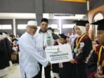 SERAHKAN : Pj Sekda Kabupaten Kotim, Masri saat menyerahkan bantuan kepada anak TKA dn TPA, usai diwisuda, Minggu (31/8).