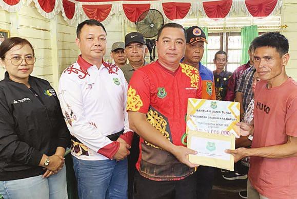 KAPUAS BANTUAN: Wakil Bupati Kapuas Dodo didampingi Sekda Kapuas Dr Usis I Sangkai menyerahkan bantuan bagi korban kebakaran dan banjir di Kecamatan Mandau Talawang, Minggu (12/10).