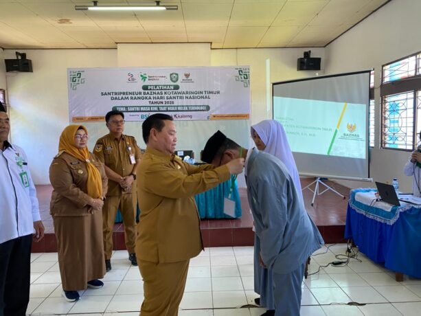 PENGALUNGAN: Bupati Kotim, Halikinnor, mengalunkan tanda pengenal pertanda dimulainya program