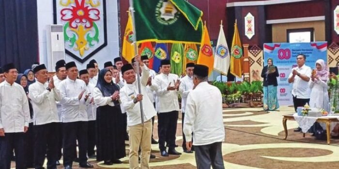 PELANTIKAN: Gubernur Kalteng H Agustiar Sabran mengibarkan bendera pataka usai dilantik sebagai Ketua DMI Kalteng oleh Ketum PP DMI HM Jusuf Kalla di Aula Jayang Tingang, Rabu (12/11).
