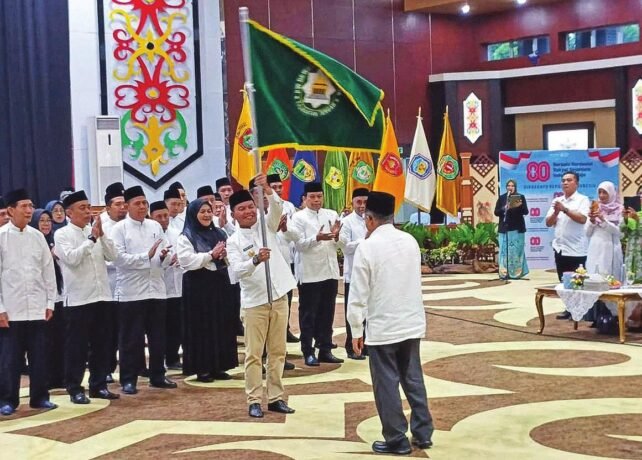 UTAMA PELANTIKAN: Gubernur Kalteng H Agustiar Sabran mengibarkan bendera pataka usai dilantik sebagai Ketua DMI Kalteng oleh Ketum PP DMI HM Jusuf Kalla di Aula Jayang Tingang, Rabu (12/11).