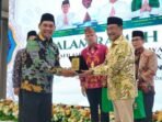 Bupati Barito Utara H. Shalahuddin saat menerima plakat dari LPTQ Kota Palangka Raya, Muara Teweh, Jumat (15/11).