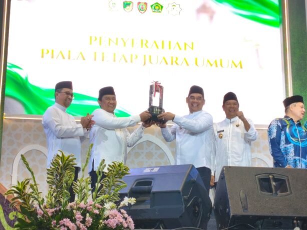 MOMEN BERSEJARAH: Bupati Barito Utara, Shalahuddin, menerima piala Juara Umum MTQH XXXIII Provinsi Kalteng dari Wakil Gubernur H. Edy Pratowo, Jumat (21/11).