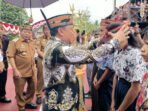 ANGKAT BUDAYA DAERAH: Wakil Ketua II Berinto memasangkan sumping saat pencanangan penggunaan lawung/sumping di lingkungan sekolah pada hari tertentu. Kegiatan berlangsung di Huma Betang Sei Pasah, Senin (8/12) pagi.