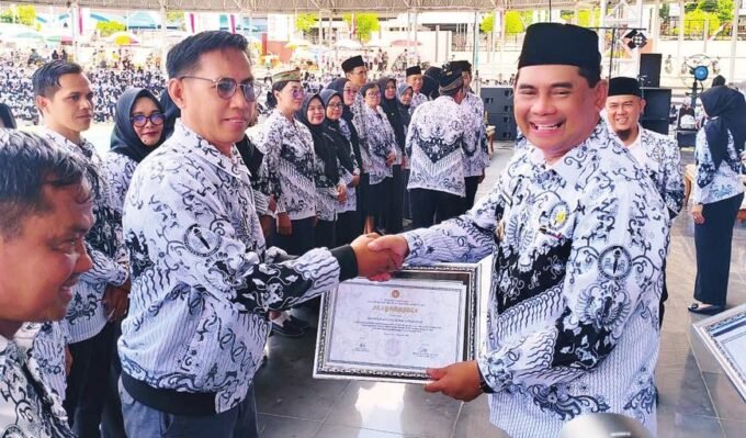 PENGHARGAAN: Bupati Shalahuddin (kanan) menyerahkan sertifikat penghargaan kepada salah satu tenaga pendidik Kecamatan Teweh Timur atas partisipasi pada HUT PGRI dan HGN Tahun 2025 di Arena Terbuka Tiara Batara, Rabu (10/12).