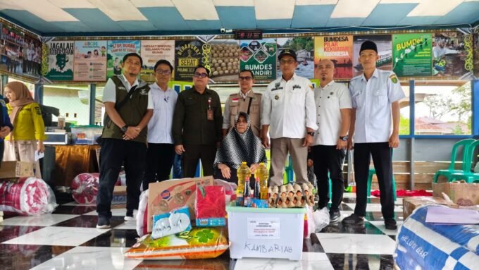 Kadinsos Barsel, Syahdani, didampingi Kades Desa Baru saat menerima bantuan dari Kemensos di Aula Kantor Desa Baru.