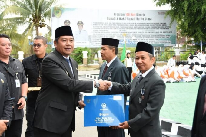 Wakil Bupati Barito Utara Felix Sonadie Y Tingan menyerahkan piagam penghargaan kepada salah satu ASN pada peringatan HAB ke-80 Kementerian Agama di halaman Kantor Bupati Barito Utara, Sabtu (3/1).