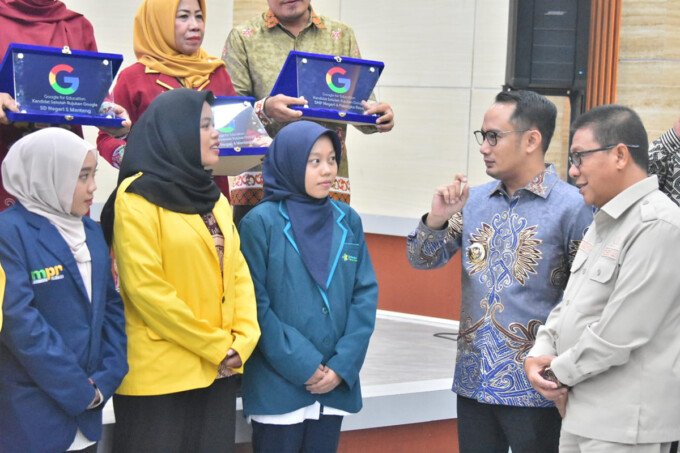 Ketua DPRD Kota Palangka Raya, Subandi (dua dari kanan) mendampingi Wali Kota Palangka Raya, Fairid Naparin menyalurkan beasiswa kepada mahasiswa, di Aula Disdik Kota, Kamis (2/4).