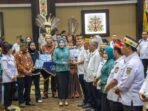 Ketua TP PKK Kalteng Aisyah Thisia Agustiar Sabran memberikan piala kepada Bupati Gunung Mas Jaya S Monong karena dinilai unggul dalam aspek konvergensi program saat Rakorda di Aula Jayang Tingang Lantai II, Rabu (29/4).