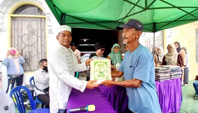19.1 Keluarga bersar H Tajeri bersama sang isteri Hj Sofia dan putra putrinya menyalurkan zakat harta kepada warga masyarakat secara simbolis di halaman rumah H Tajeri, Jalan A Yani Muara Teweh, Selasa (17/3/2026).