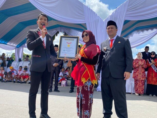Bunda PAUD Kabupaten Lamandau, Norol Latifah (tengah), didampingi Bupati Lamandau, Rizky Aditya Putra (kanan) menerima penghargaan Rekor Muri, di kawasan Bundaran Rusa, Nanga Bulik, Senin (4/5).