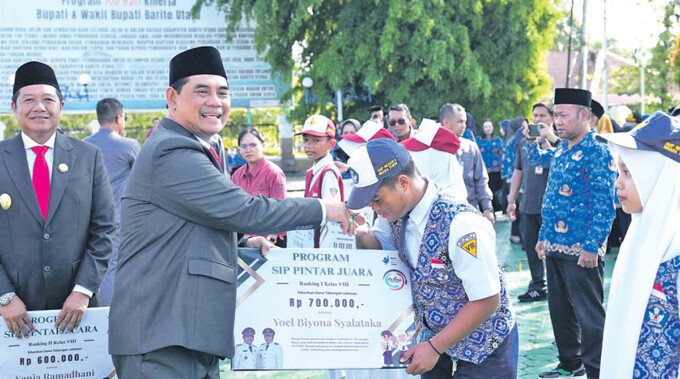 Bupati Barito Utara H Shalahuddin ST MT menyerahkan bantuan program SIP PINTAR JUARA secara simbolis kepada Yoel Binoya Syalataka, salah satu siswa SMPN 2 Muara Teweh pasca Upacara Hardiknas di Halaman Kantor Bupati Barito Utara, Sabtu (2/5).