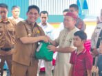 Barito Utara Bupati Barito Utara H Shalahuddin ST MT secara simbolis memberikan bantuan sosial kepada salah satu penerima pada acara Launching Bantuan Sosial Program Bantuan Sosial dan Honorarium Kelembagaan bagi Damang Adat, Mantir, dan RT/RW se-Kabupaten di Halaman Gudang Bulog, Muara Teweh, Senin (22/6).