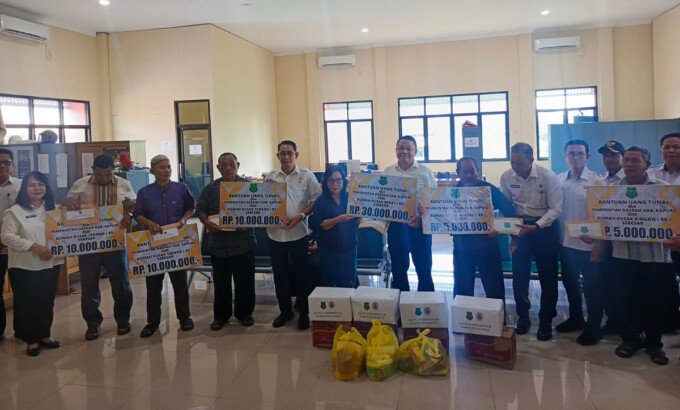 Sekda Kapuas Dr Usis I Sangkai menyerahkan secara simbolis bantuan uang tunai kepada warga korban kebakaran dan angin puting beliung pada kegiatan penyaluran bantuan di Kantor BPBD Kapuas, Rabu (24/6).