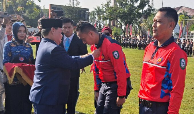 Bupati Kotawaringin Timur H. Halikinnor mengalungkan tanda anggota kepada Relawan Pemadam Kebakaran (Redkar) saat peresmian di halaman Kantor Bupati Kotim, Senin (1/6).