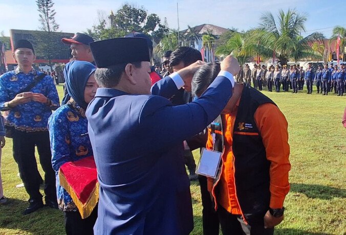 Bupati Kabupaten Kotim H. Halikinnor secara simbolis mengalungkan tanda pengenal kepada petugas Sensus Ekonomi 2026 saat Apel Siaga Sensus Ekonomi 2026, Senin (1/6).
