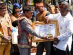 Bupati Lamandau, Rizky Aditya Putra (kiri), saat menyaksikan penyerahan penghargaan kepada Kepala Desa Beruta pada puncak peringatan Hari Jadi ke-69 Kalteng di Palangka Raya, Sabtu (23/5).