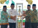 Penyerahan piala bergilir pada pembukaan MTQH ke-53 Kabupaten Barito Utara dari Camat Teweh Tengah Dudy Bagus P kepada Bupati Barito Utara H Shalahuddin ST MT yang didampingi oleh Ketua Panitia H Mastur di Aula Dinas Lingkungan Hidup (DLH) Kabupaten Barito Utara, Sabtu siang (25/7).