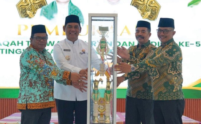 Barito Utara2 Penyerahan piala bergilir pada pembukaan MTQH ke-53 Kabupaten Barito Utara dari Camat Teweh Tengah Dudy Bagus P kepada Bupati Barito Utara H Shalahuddin ST MT yang didampingi oleh Ketua Panitia H Mastur di Aula Dinas Lingkungan Hidup (DLH) Kabupaten Barito Utara, Sabtu siang (25/7).