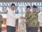 Piala Bergilir Juara Umum MTQH ke-53 Kabupaten Barito Utara diserahkan oleh Bupati H Shalahuddin ST MT kepada peraih juara satu yang diterima Plt Camat Teweh Tengah Dudy Bagus Prasetyo dan Ketua Rombongan Kafilah Teweh Tengah, Patih Herman di Aula Dinas Lingkungan Hidup setempat, Senin (27/7).