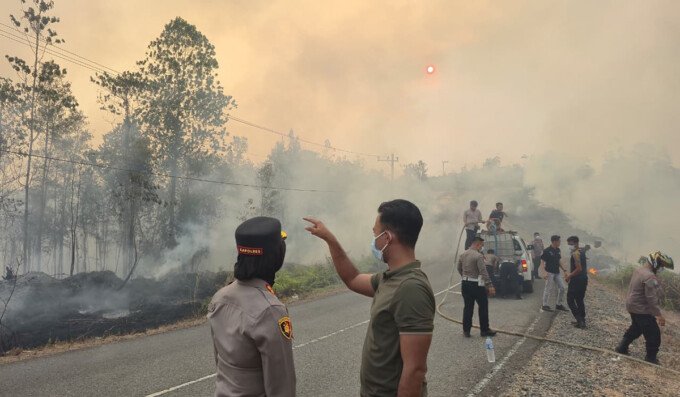 Kapolres Gunung Mas AKBP Arum Sari Puspita Dewi memimpin langsung personel dalam penanganan kebakaran di Jalan Lintas Kurun-Tewah, Selasa (18/8).