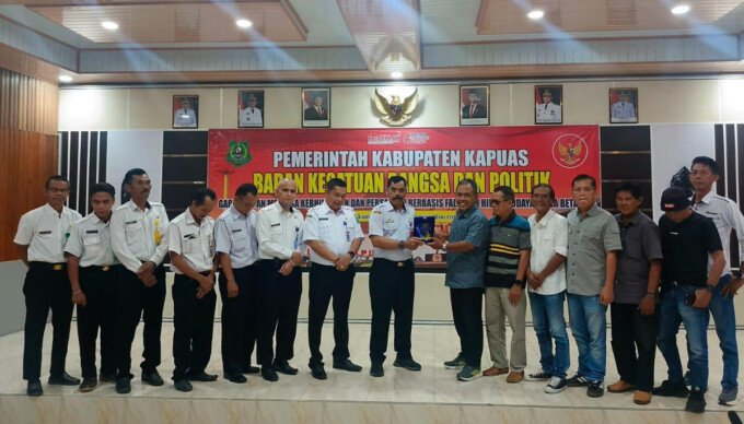 Ketua PWI Kapuas Suhartoyo memberikan plakat PWI Kepada Kepala Badan Keabangpol Kapuas Yunabut, Rabu (9/9).