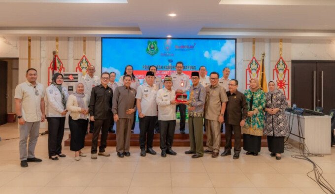 Bupati Kapuas HM Wiyatno menerima plakat dari Komisi I DPRD Kalteng.